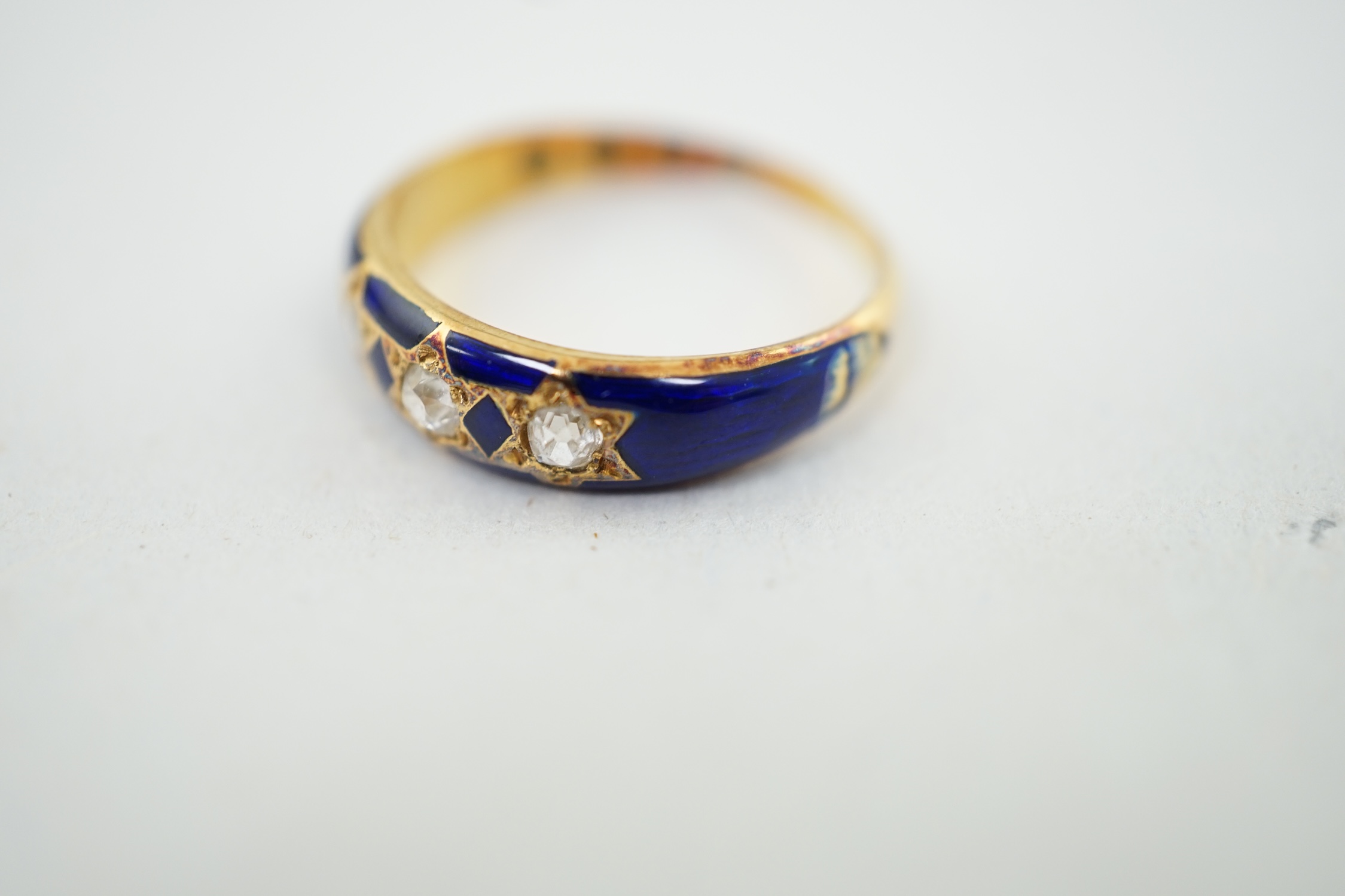 A late Victorian 18ct gold, three stone diamond and blue enamel set ring